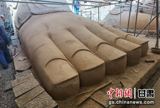 圖為中國“石窟鼻祖”天梯山石窟第13窟大佛足部與局部危巖體搶救性保護項目施工現(xiàn)場。陳曉斌 攝