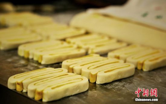 圖為面劑被涂上胡麻油，切成條狀用作月餅的花型制作。張文 攝