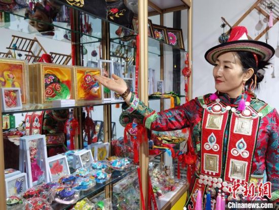 圖為身著民族服飾的隴原巧手展示手工藝品。(資料圖) 徐雪 攝