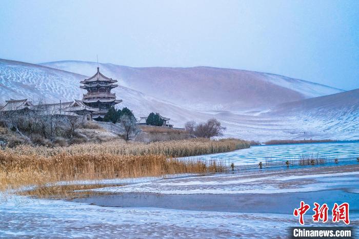 2021年11月28日，雪落鳴沙山月牙泉景區(qū)?！⊥醣筱y 攝
