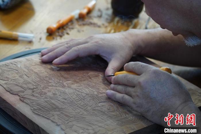 圖為徐晉林湊近木板，近距離制作雕版畫?！【琶赖┰?　攝