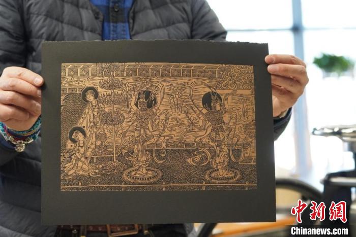 圖為手工書藝人展示敦煌雕版壁畫印刷品?！【琶赖┰?　攝