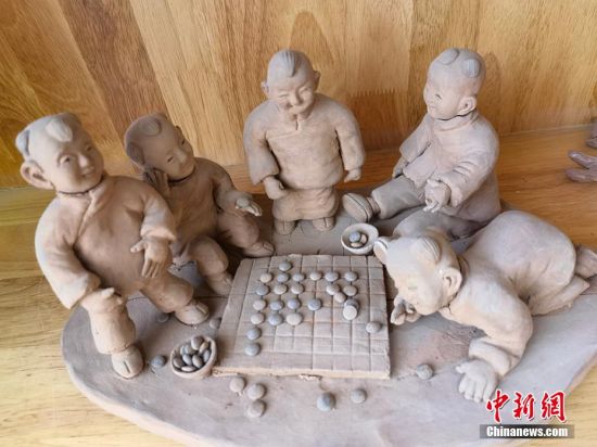 圖為泥塑作品展現(xiàn)下棋場景。 劉玉桃 攝