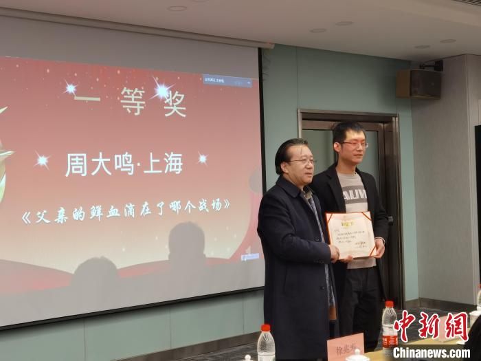 圖為作家、西北師范大學(xué)新聞與傳媒學(xué)院院長徐兆壽頒發(fā)一等獎證書，代領(lǐng)獎?wù)呱吓_領(lǐng)獎。　楊娜 攝