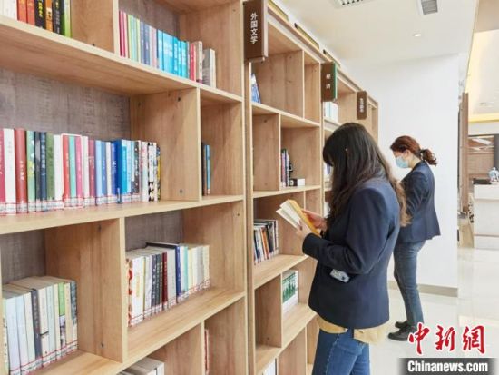 圖為在甘肅公航旅建設(shè)集團(tuán)有限公司的職工書屋，職工挑選書籍?！⌒煅?攝