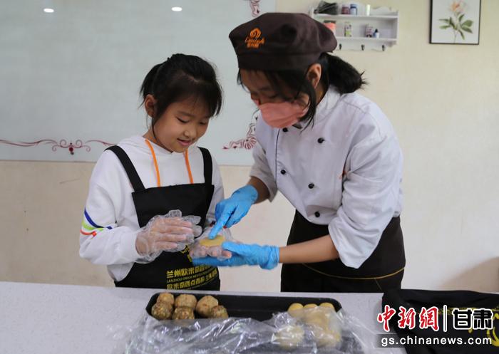 圖為在甘臺胞小朋友在工作人員指導(dǎo)下制作月餅。九美旦增 攝