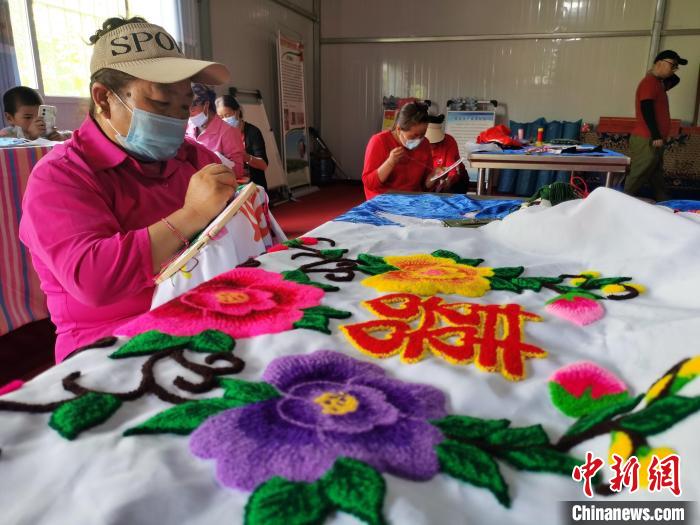 圖為婦女制作青繡?！?zhí)砀?攝