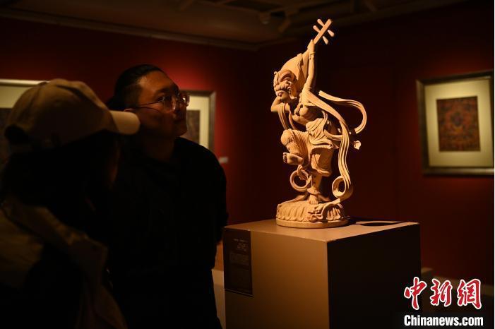 圖為季茂杰向參觀者介紹自己創(chuàng)作敦煌木雕的過程。李亞龍 攝</p>
<p>