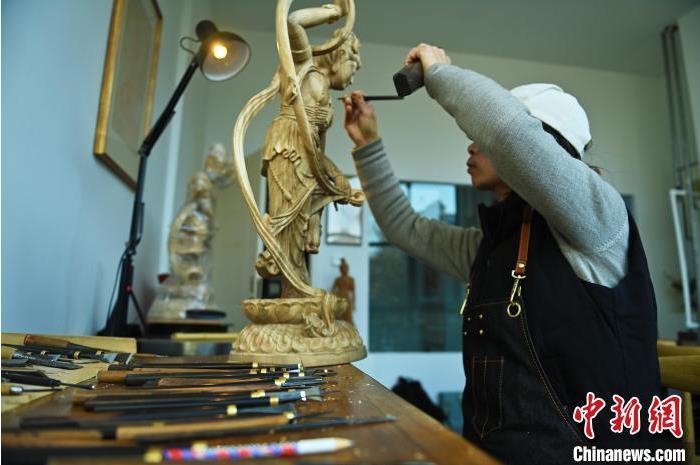 圖為季茂杰進行敦煌元素的木雕創(chuàng)作。李亞龍 攝</p>
<p>