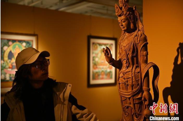圖為季茂杰觀察自己創(chuàng)作的敦煌木雕。李亞龍 攝</p>
<p>