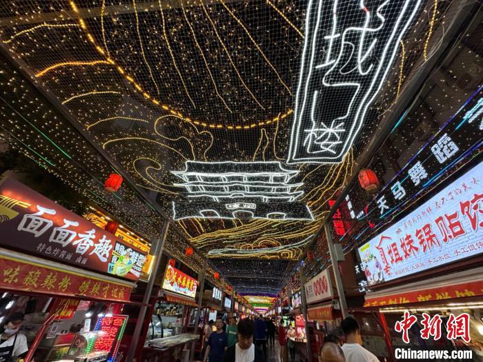 圖為明清街夜市燈光點(diǎn)亮具有武威文化元素的“涼州古城門”彩燈?！〈魑牟?攝</p><p>