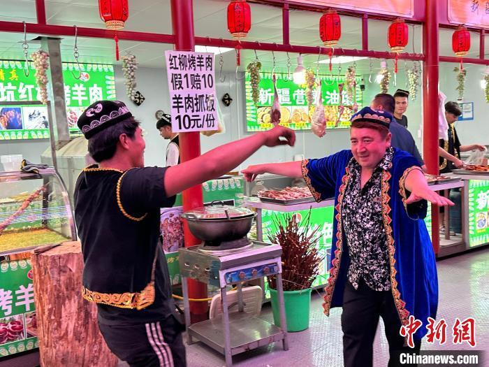 圖為餐飲經(jīng)營者在“西涼不夜城”跳起舞蹈引客?！〈魑牟?攝</p><p>