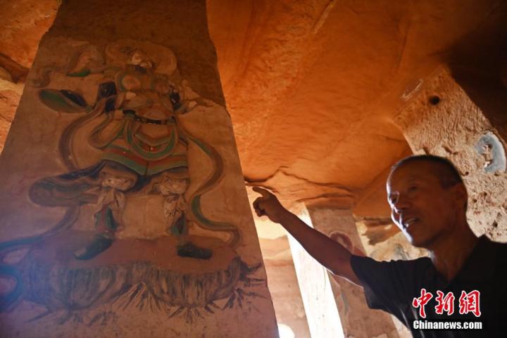 7月15日，甘肅省平?jīng)鍪袥艽h百里石窟長廊羅漢洞石窟內(nèi)，該窟文保員郭建平介紹窟內(nèi)石刻彩繪壁畫。郭建平家中三代人曾自發(fā)保護(hù)羅漢洞石窟。羅漢洞石窟遺存40余個(gè)窟龕，以北魏至清代風(fēng)格為主。中新社記者 李亞龍 攝</p>
<p>