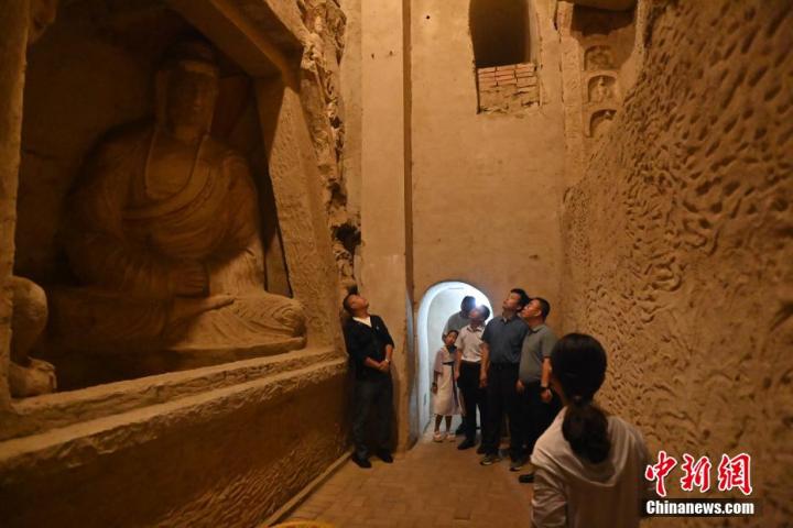 7月15日，游人參觀甘肅省平?jīng)鍪袥艽h百里石窟長廊中的王母宮石窟。百里石窟長廊位于涇川縣境內(nèi)，由512個(gè)石窟、5眼窟中石井組成，現(xiàn)存王母宮石窟、鳳凰山石窟、南石窟寺、丈八寺石窟、羅漢洞石窟、太山寺石窟等規(guī)模較大的石窟群，還有數(shù)量眾多的小石窟群。王母宮石窟又名千佛洞，該窟設(shè)計(jì)宏大，造像生動(dòng)，窟內(nèi)擁有造像數(shù)百尊，是較為珍貴的佛教文化歷史遺存。中新社記者 李亞龍 攝</p>
<p>