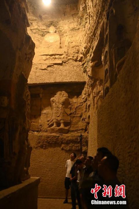 7月15日，游人參觀甘肅省平?jīng)鍪袥艽h百里石窟長廊中的王母宮石窟。百里石窟長廊位于涇川縣境內(nèi)，由512個(gè)石窟、5眼窟中石井組成，現(xiàn)存王母宮石窟、鳳凰山石窟、南石窟寺、丈八寺石窟、羅漢洞石窟、太山寺石窟等規(guī)模較大的石窟群，還有數(shù)量眾多的小石窟群。王母宮石窟又名千佛洞，該窟設(shè)計(jì)宏大，造像生動(dòng)，窟內(nèi)擁有造像數(shù)百尊，是較為珍貴的佛教文化遺存。中新社記者 李亞龍 攝</p>
<p>