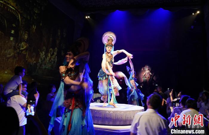 《樂動敦煌》是全球首部洞窟式沉浸體驗劇，利用真人與數字影像虛實交換實現沉浸式體驗。圖為2023年8月28日晚，《樂動敦煌》演出。(資料圖)中新社記者 毛建軍 攝