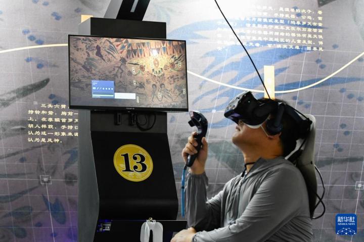 7月22日，游客借助VR設(shè)備沉浸式游覽莫高窟第285窟虛擬場景。新華社記者 郎兵兵 攝